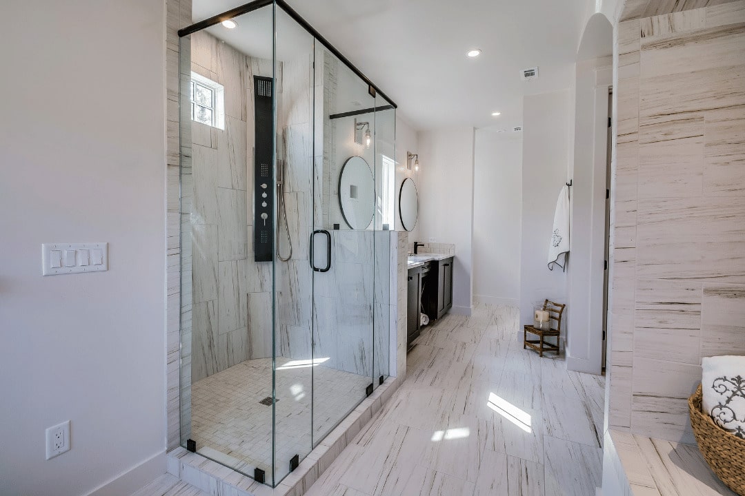 Bright bathroom with a glass-enclosed walk-in shower, vanity and recessed ceiling lights