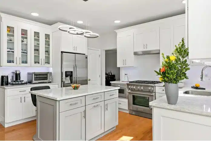 White upper kitchen cabinets with glass doors arranged symmetrically around a central window
