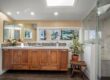 Narrow galley-style kitchen featuring modern white cabinetry and sleek black countertops