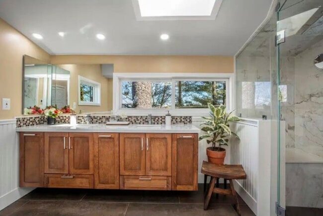 Narrow galley-style kitchen featuring modern white cabinetry and sleek black countertops