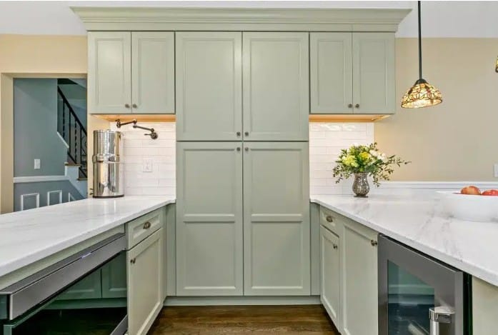 Bright open kitchen featuring a vibrant blue island with a quartz countertop and wooden stools