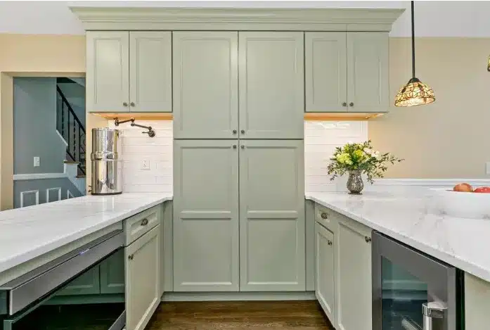 Bright open kitchen featuring a vibrant blue island with a quartz countertop and wooden stools